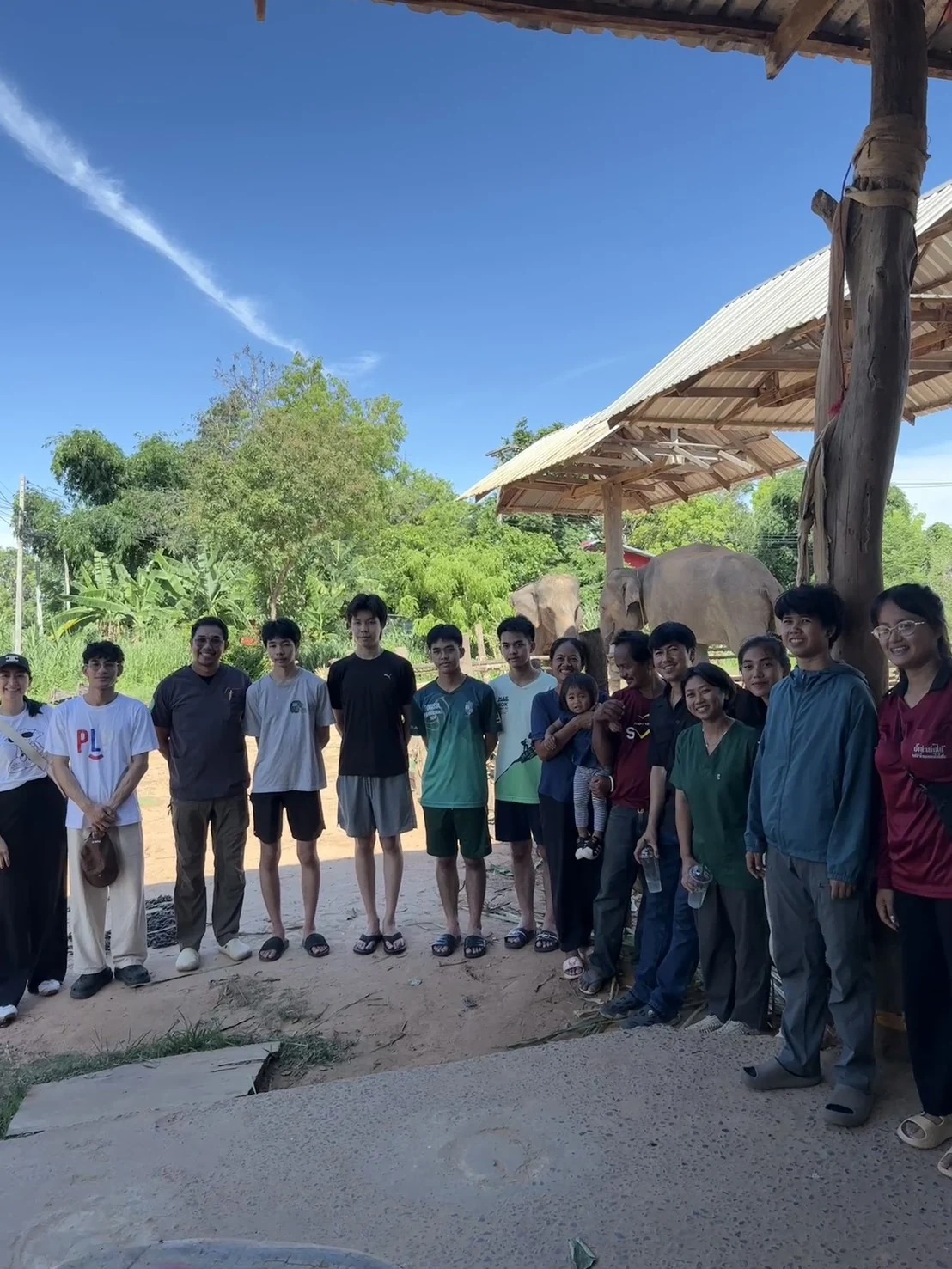 Activity participants standing together with elephants in the background